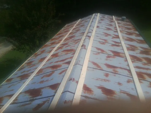 Rusted metal roof panels with new wood purlins before replacement — Storm Damage Roof Repair in Avon by Roofing Brothers
