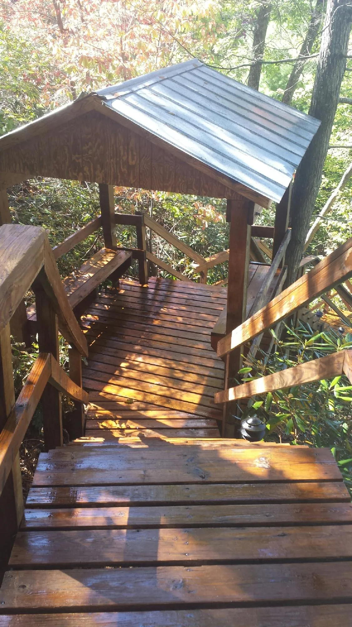 Freshly stained wood walkway and covered shelter with a metal roof in Avon